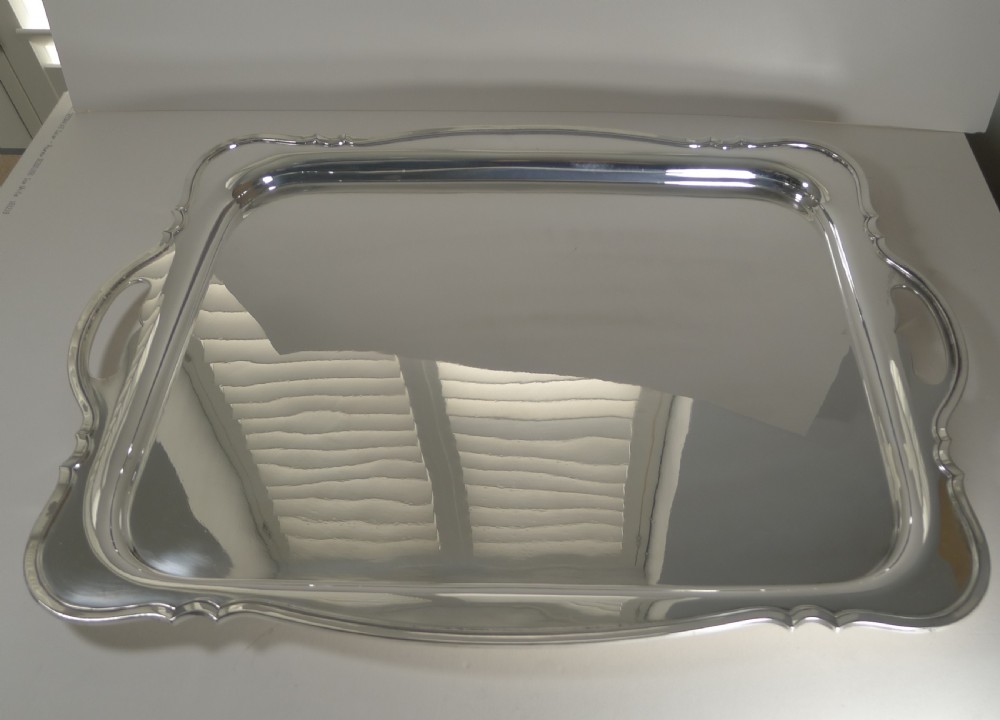 A rectangular silver-plated serving tray featuring moulded scalloped edges, integrated side handles, and a polished reflective surface. View II