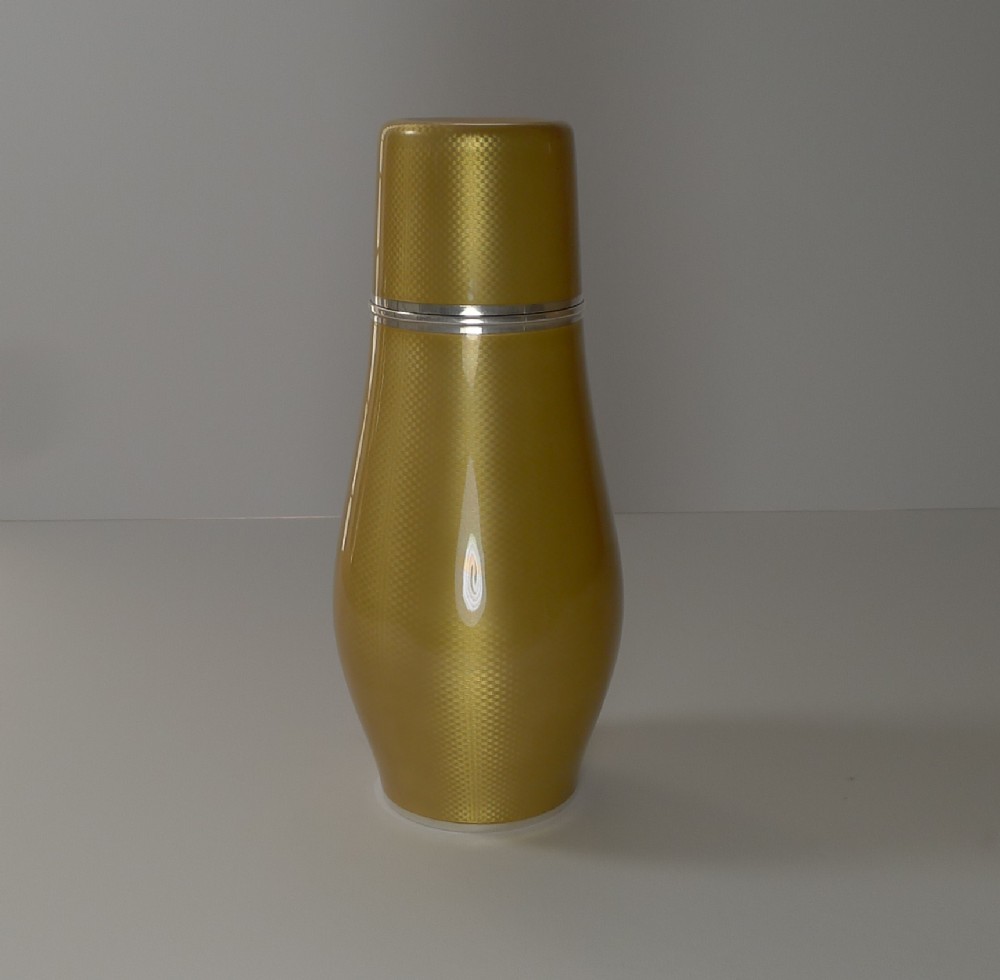 A yellow guilloche enamel and sterling silver cocktail shaker with engine-turned geometric detailing.
