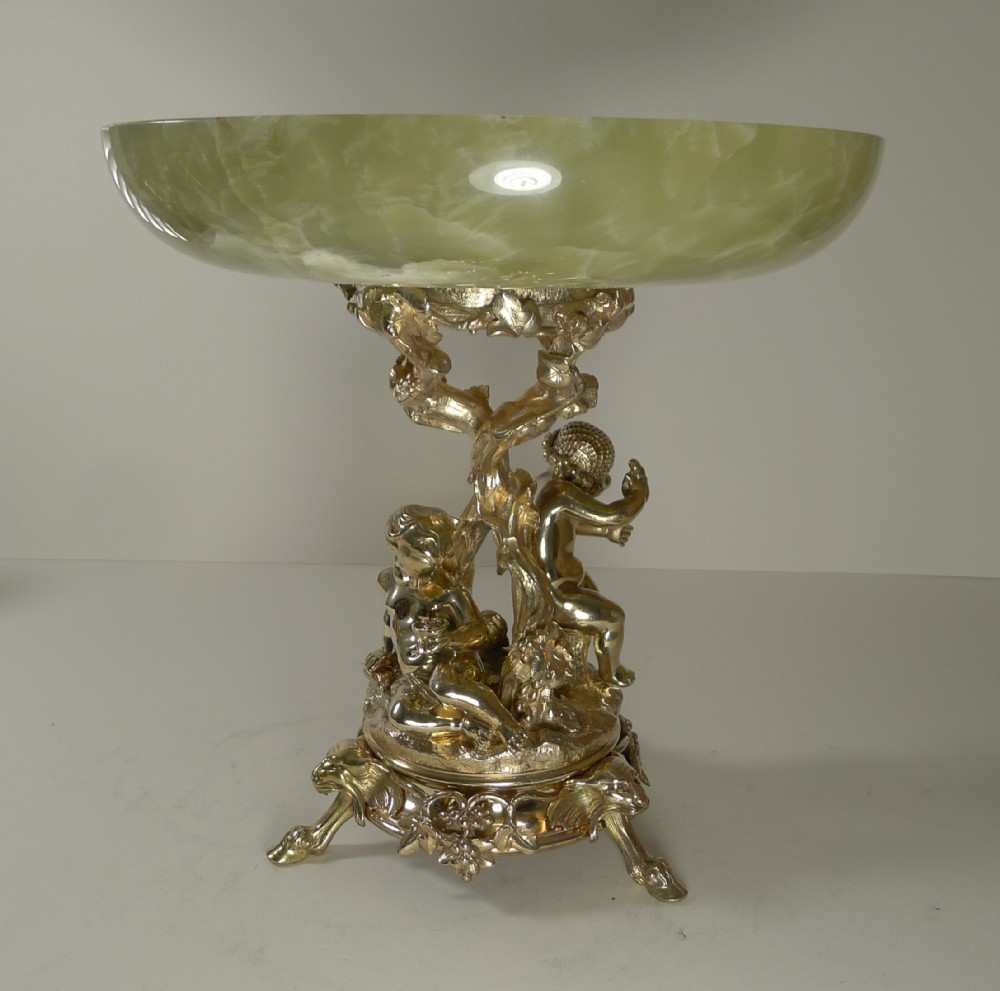 A 19th-century French gilded bronze centrepiece featuring sculpted cherubs around a central trunk stem supporting a shallow green onyx bowl.