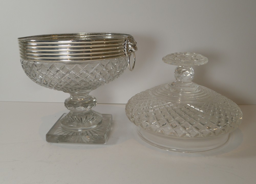 A diamond-cut crystal bowl with a matching faceted lid, resting on a square pedestal base and fitted with a ribbed silver rim with side drop rings. View XIV