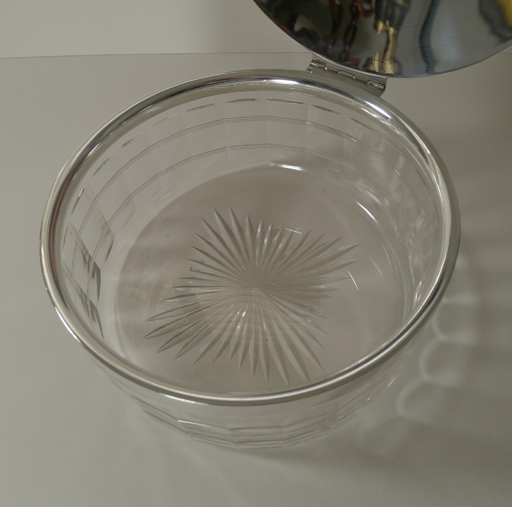 A circular clear cut glass dish with a fitted polished silver-plated lid and rim, dating from circa 1920. View VII