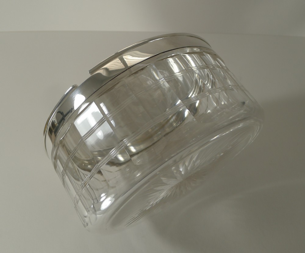 A circular clear cut glass dish with a fitted polished silver-plated lid and rim, dating from circa 1920. View VIII