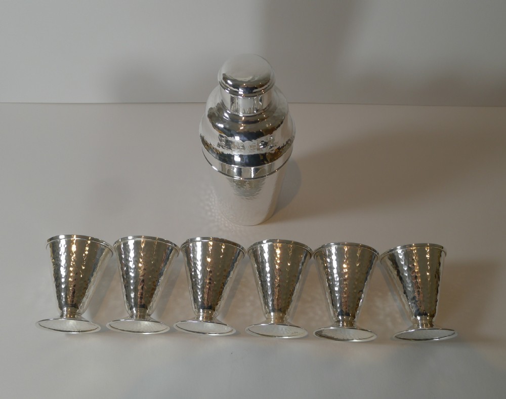 An Art Deco silver-plated cocktail shaker set with a hammered texture, featuring a central shaker flanked by six matching flared goblets. View III