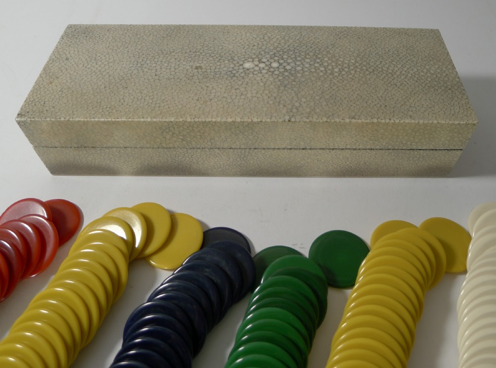 A rectangular Art Deco cream shagreen box positioned behind multiple stacks of colourful circular gaming counters.