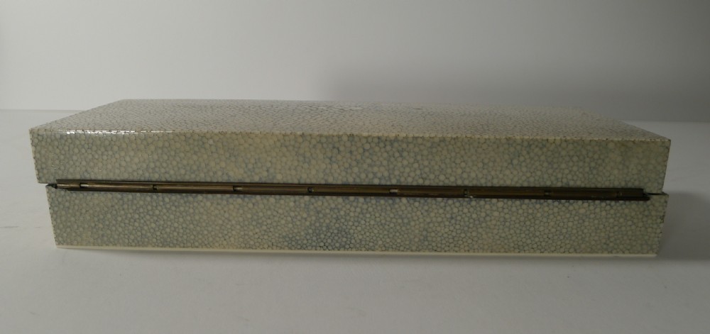 A rectangular Art Deco cream shagreen box positioned behind multiple stacks of colourful circular gaming counters. View V