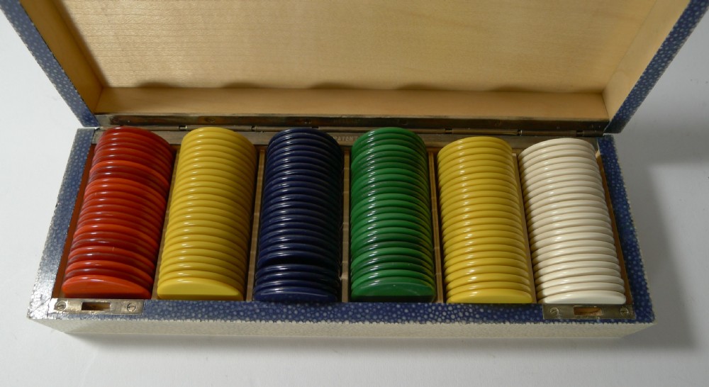 A rectangular Art Deco cream shagreen box positioned behind multiple stacks of colourful circular gaming counters. View X
