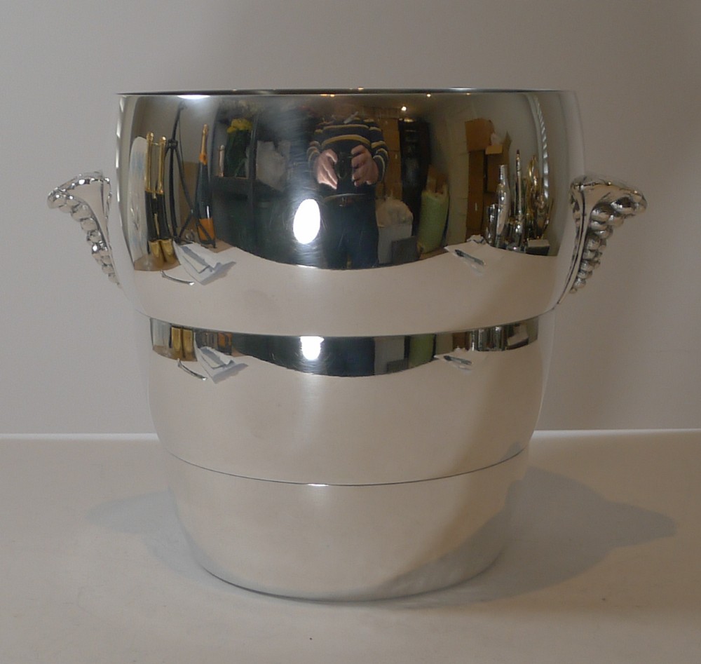 A polished silver-plated Art Deco champagne bucket featuring tiered concentric rings and sculpted side handles.
