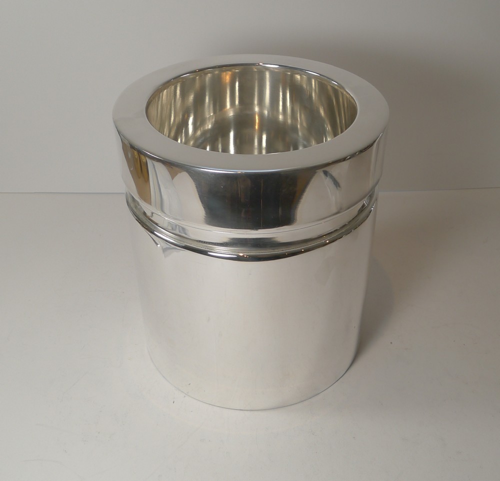 A polished silver-plated cylindrical wine cooler featuring a thick double-walled rim and smooth metallic surface.