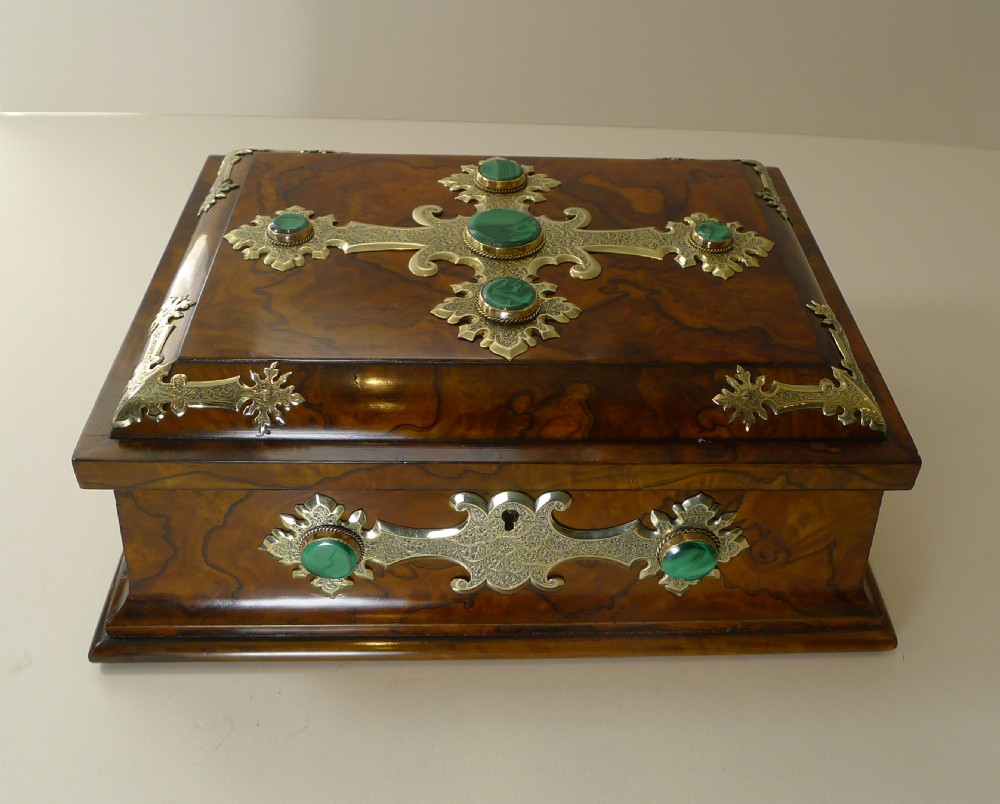 A rectangular burr walnut box decorated with engraved brass strapwork and inset green malachite cabochons.
