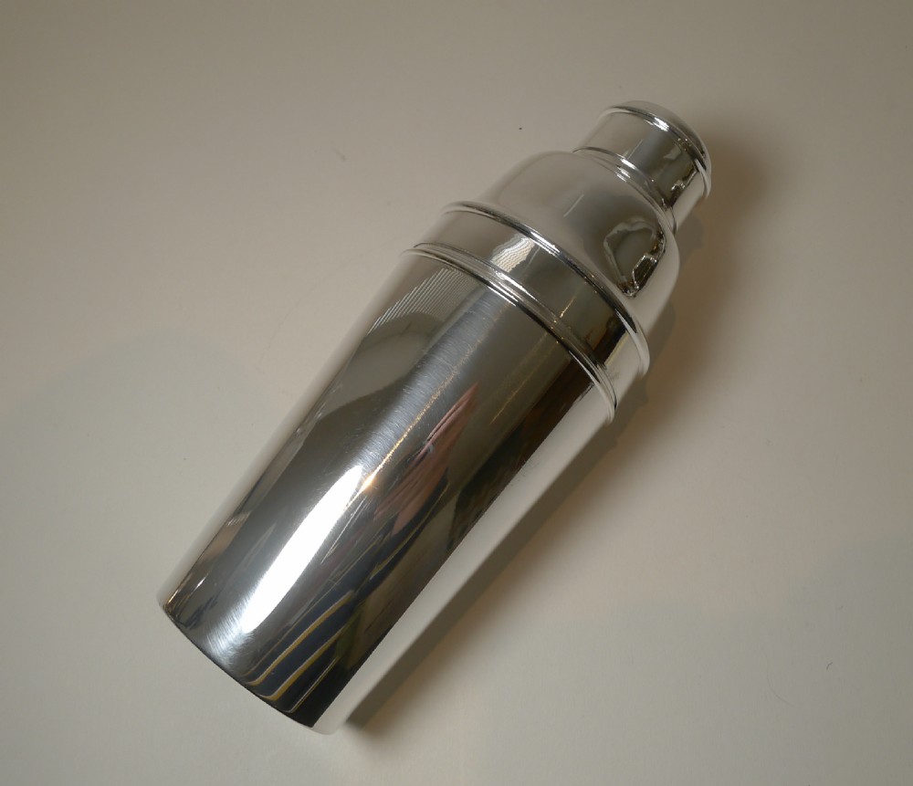A polished silver-plated three-piece Art Deco cocktail shaker featuring stepped rims and a tapered body. View VI