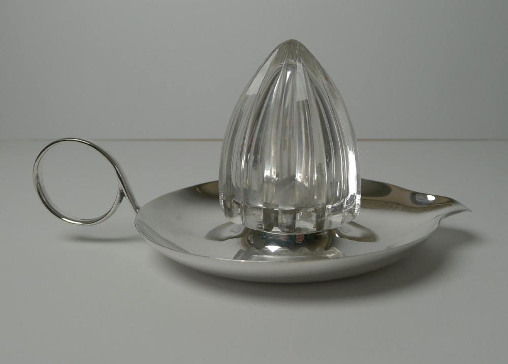 An Edwardian silver plated tray featuring a single loop handle, pouring spout, and a central faceted cut crystal lemon squeezer cone.