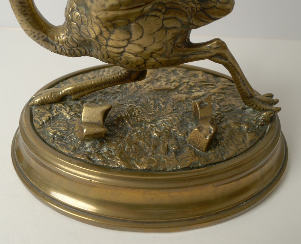 A cast brass antique inkwell shaped like a running ostrich mounted on a moulded oval base with an integrated pen rest. View III