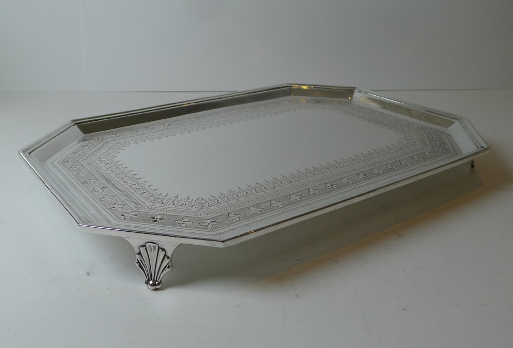 An octagonal silver-plated drinks tray featuring an engraved geometric border, raised rim, and small shell feet. View III