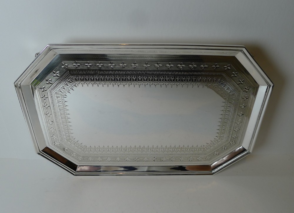 An octagonal silver-plated drinks tray featuring an engraved geometric border, raised rim, and small shell feet. View VII