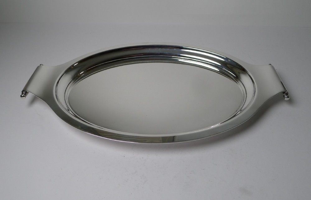 A polished silver-plated oval Art Deco cocktail tray featuring integrated curved handles with spherical accents.