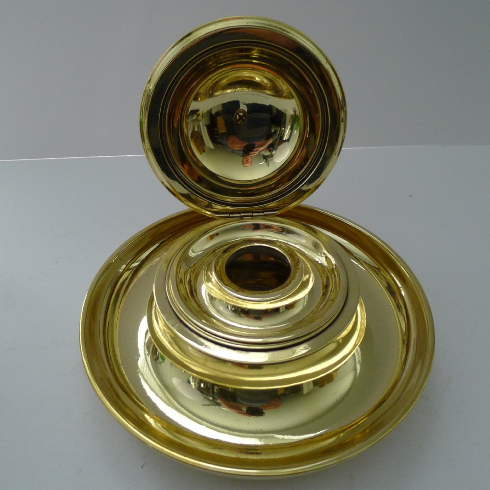 A Victorian novelty inkwell featuring a silvered owl head with yellow glass eyes resting on a circular polished brass dish base. View V