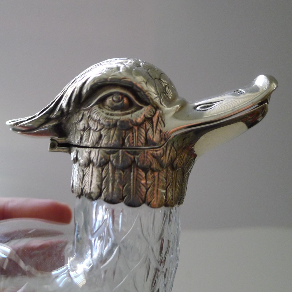 A Victorian cut glass and silver decanter shaped as a duck with a detailed silver head spout and glass body. View III