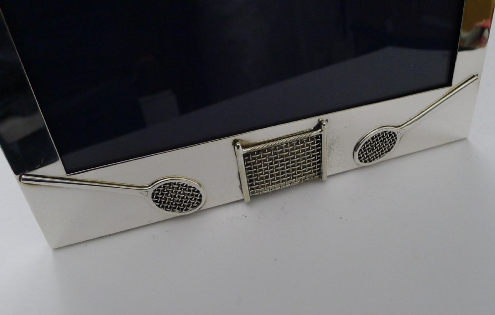 A rectangular sterling silver picture frame featuring miniature relief tennis rackets and a net motif at the bottom edge. View III
