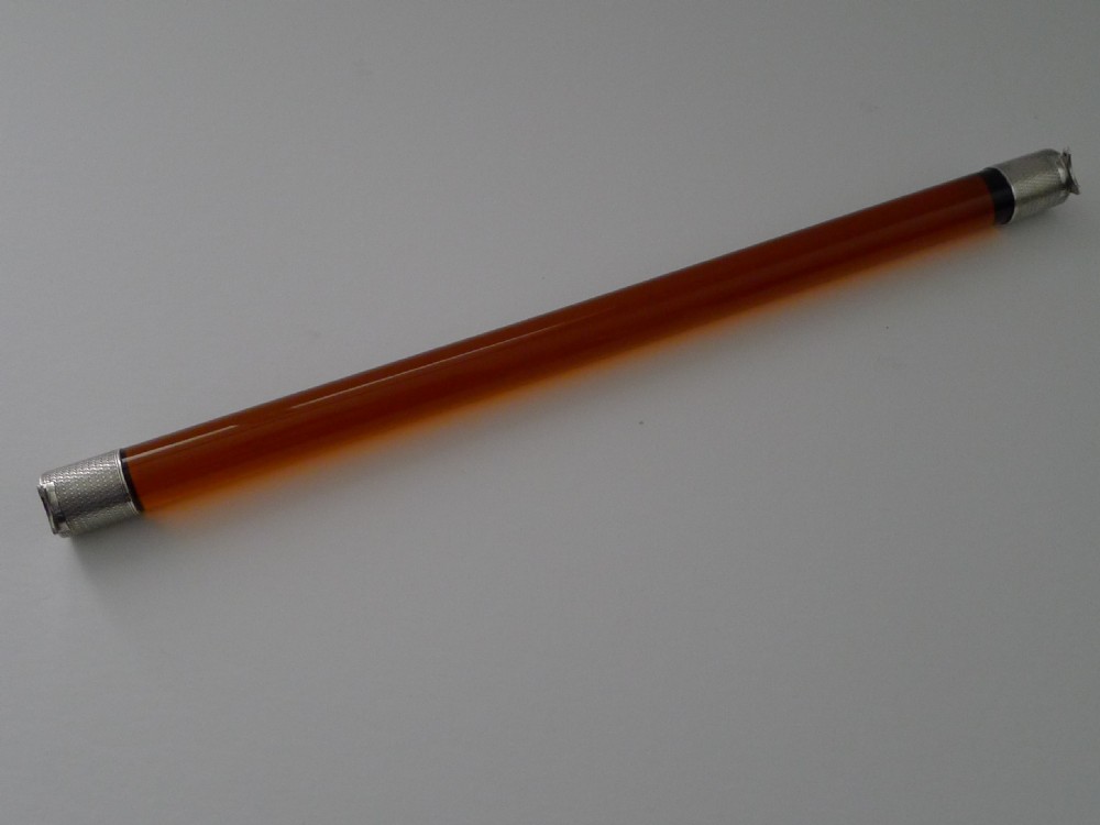 A cylindrical amber glass ruler with textured sterling silver caps fitted to each end. View V