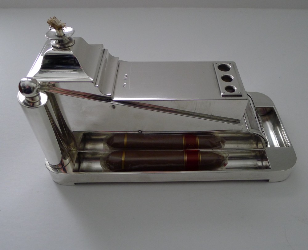 A Victorian polished silver cigar compendium designed in a mechanical trolley shape with wheels, match holders, and cigar troughs. View II