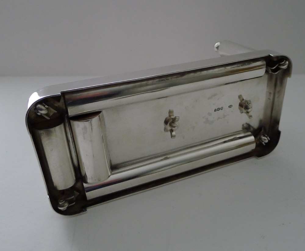 A Victorian polished silver cigar compendium designed in a mechanical trolley shape with wheels, match holders, and cigar troughs. View XII