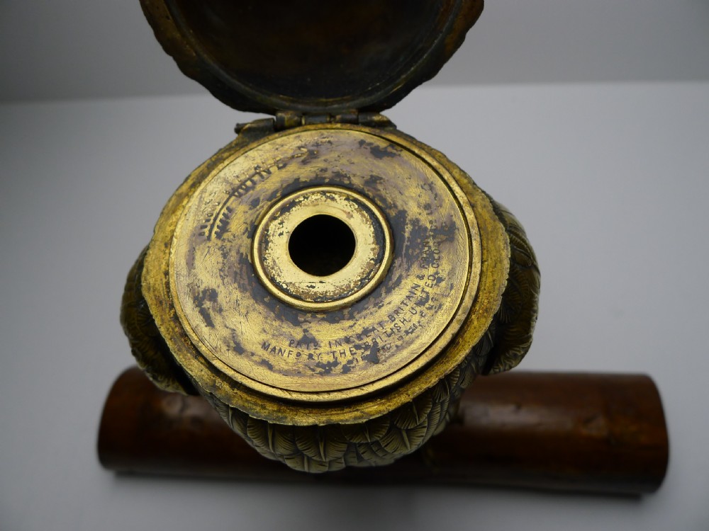 A detailed Victorian cast brass owl sculpture functioning as an inkwell, set upon a naturalistic wooden log base with yellow glass eyes. View V