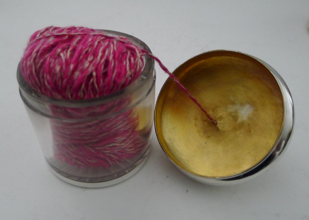 A cylindrical clear glass jar featuring a domed sterling silver lid with a top cutter attachment. View VII
