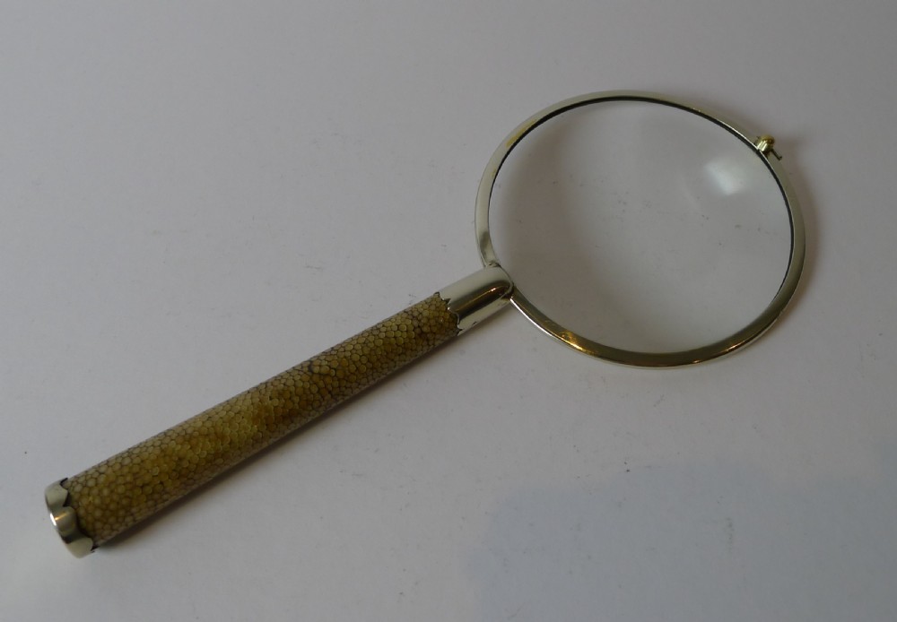 An Art Deco magnifying glass featuring a circular silver-plated rim and a textured brown shagreen cylindrical handle with silver mounts. View II