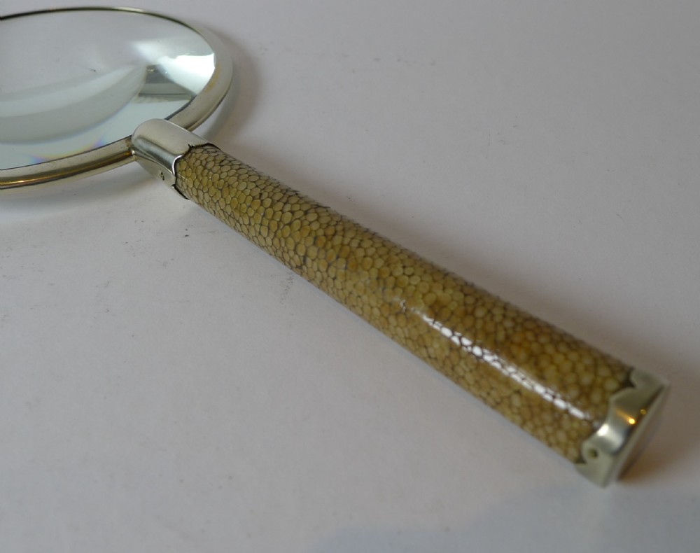 An Art Deco magnifying glass featuring a circular silver-plated rim and a textured brown shagreen cylindrical handle with silver mounts. View IV