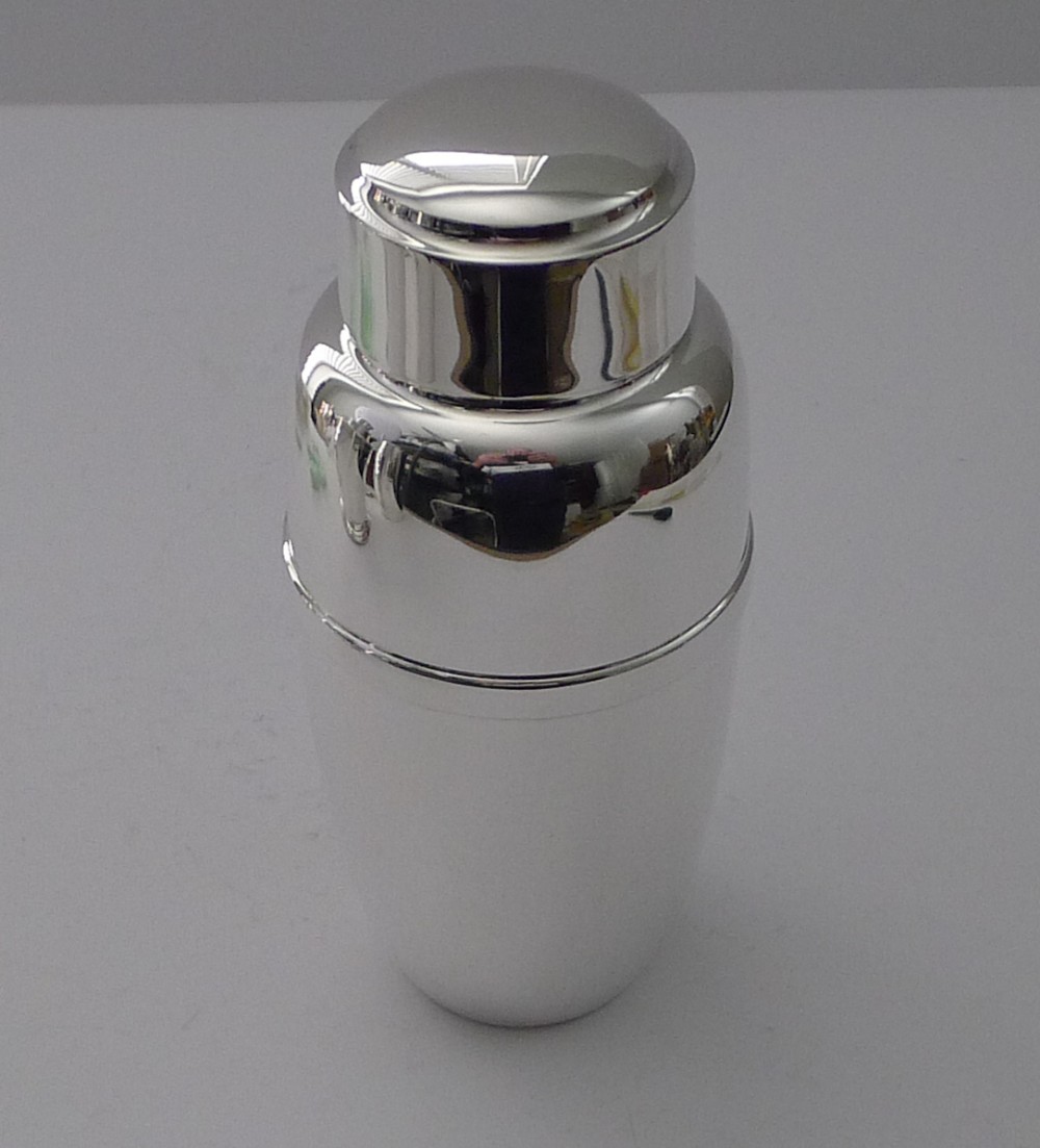 A polished three-piece Art Deco silver-plated cocktail shaker with a smooth cylindrical body and stepped cap.