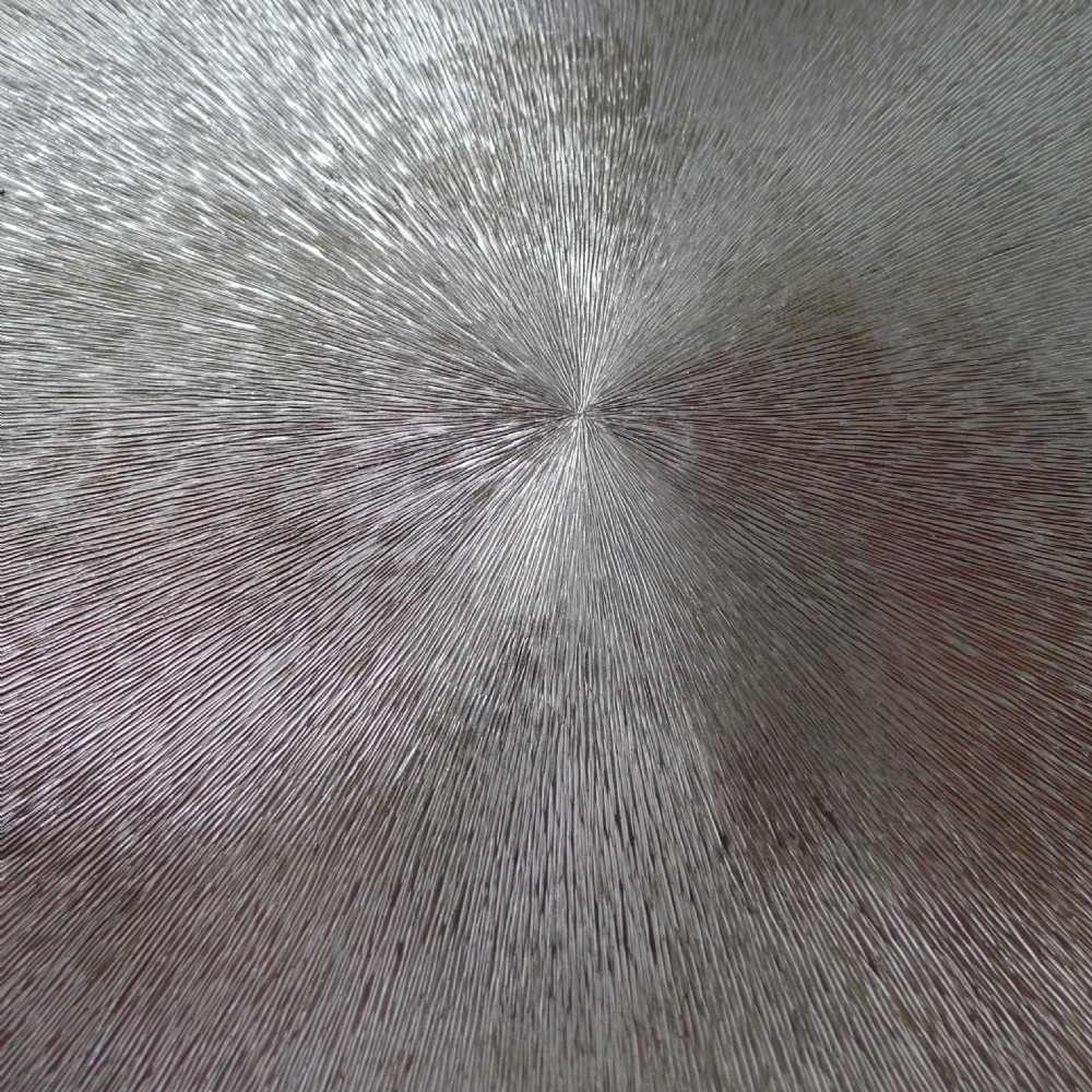A circular silver-plated cocktail tray featuring a textured sunburst pattern at the centre and a beaded rim. View III