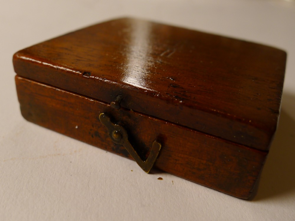 An antique mahogany cased compass by Stanley London featuring a square dark wood hinged box housing a circular brass dial and directional needle. View V