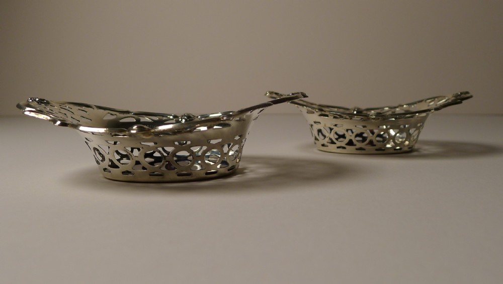 A pair of oval pierced sterling silver decorative baskets featuring scalloped borders and dark tortoiseshell bases. View VI
