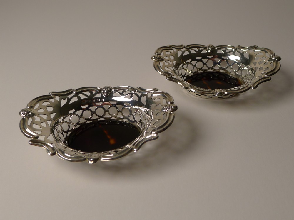 A pair of oval pierced sterling silver decorative baskets featuring scalloped borders and dark tortoiseshell bases. View VII