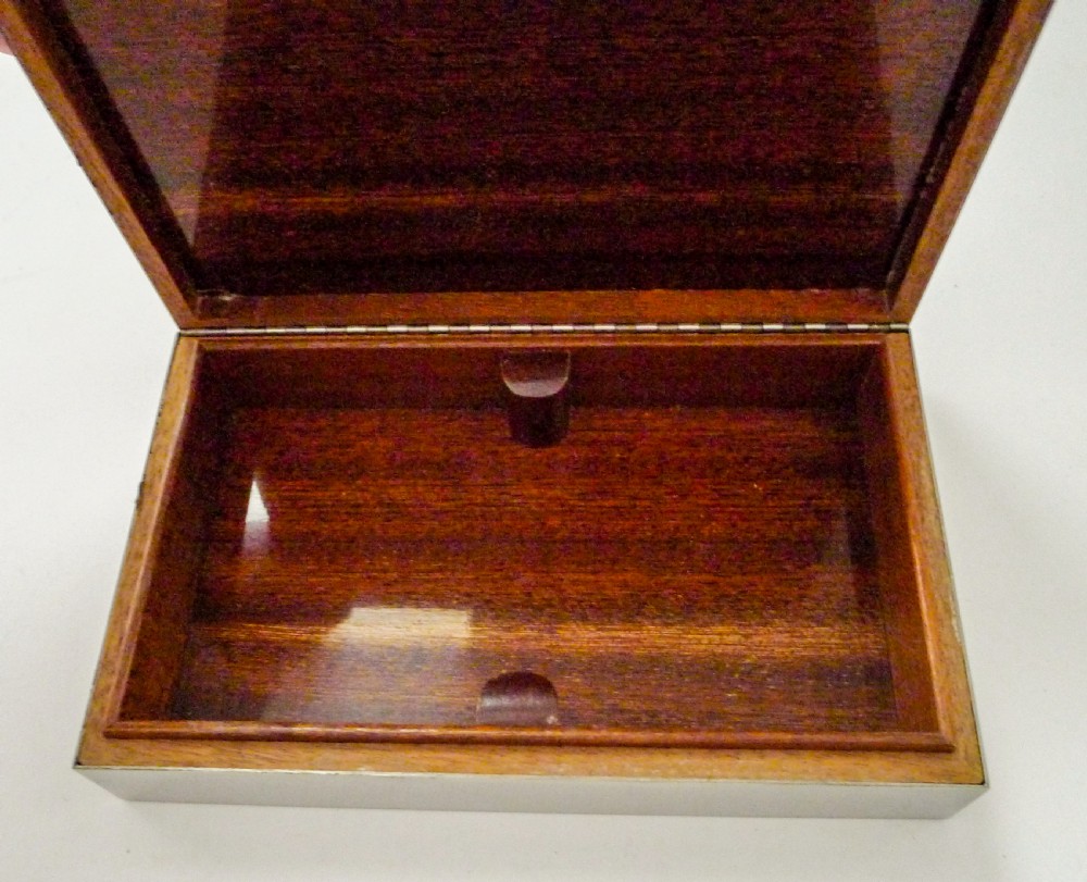 A rectangular silver table box featuring a geometric wire-wrapped border detail and double G emblem on the hinged lid. View XIII