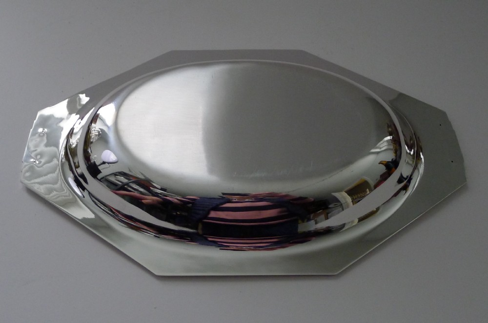 A polished French Art Deco silver plated bowl featuring an elongated octagonal shape with stepped geometric handles at each end. View IX