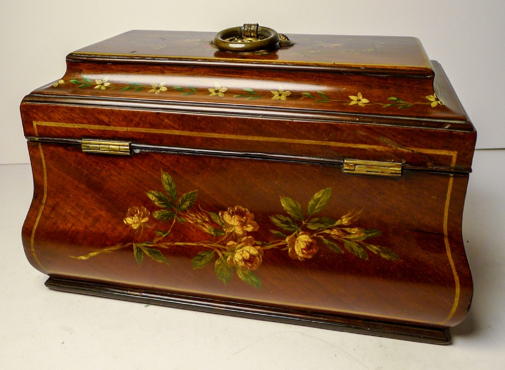 A hand-painted Regency mahogany tea caddy featuring floral decoration, a stepped lid, a brass ring handle, and a keyhole escutcheon. View V