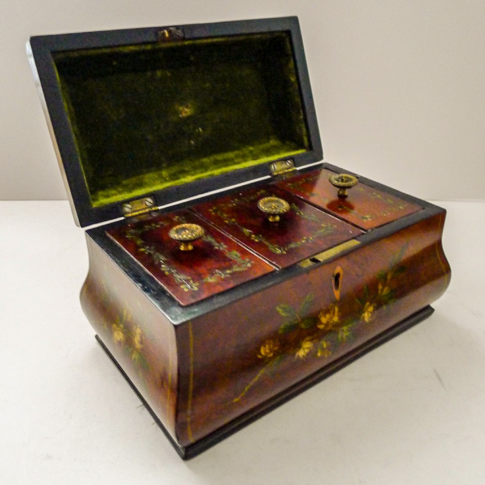 A hand-painted Regency mahogany tea caddy featuring floral decoration, a stepped lid, a brass ring handle, and a keyhole escutcheon. View VI