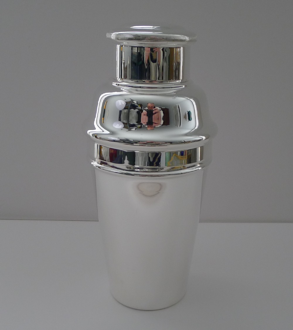 An Art Deco silver plated three-piece cocktail shaker with a polished finish and stepped cap.