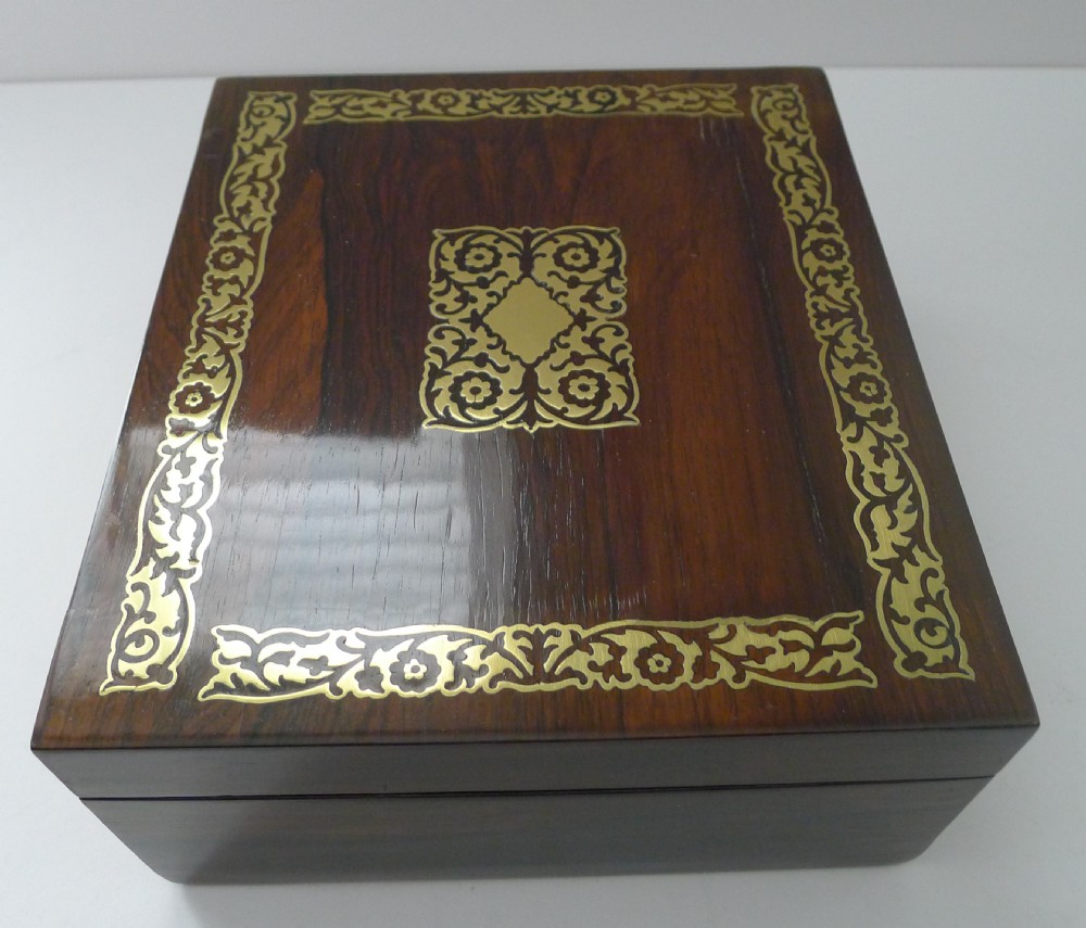 Rectangular dark rosewood jewellery box with elaborate cut-brass floral inlay across the lid and front panel, fitted with a key and tassel. View VI