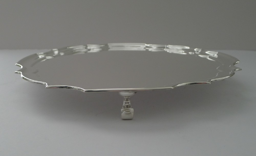 A circular silver-plated drinks tray featuring a shaped piecrust edge and a highly polished reflective surface. View III