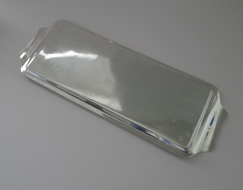 A rectangular Art Deco silver-plated drinks tray featuring integrated curved handles and a smooth polished surface. View V