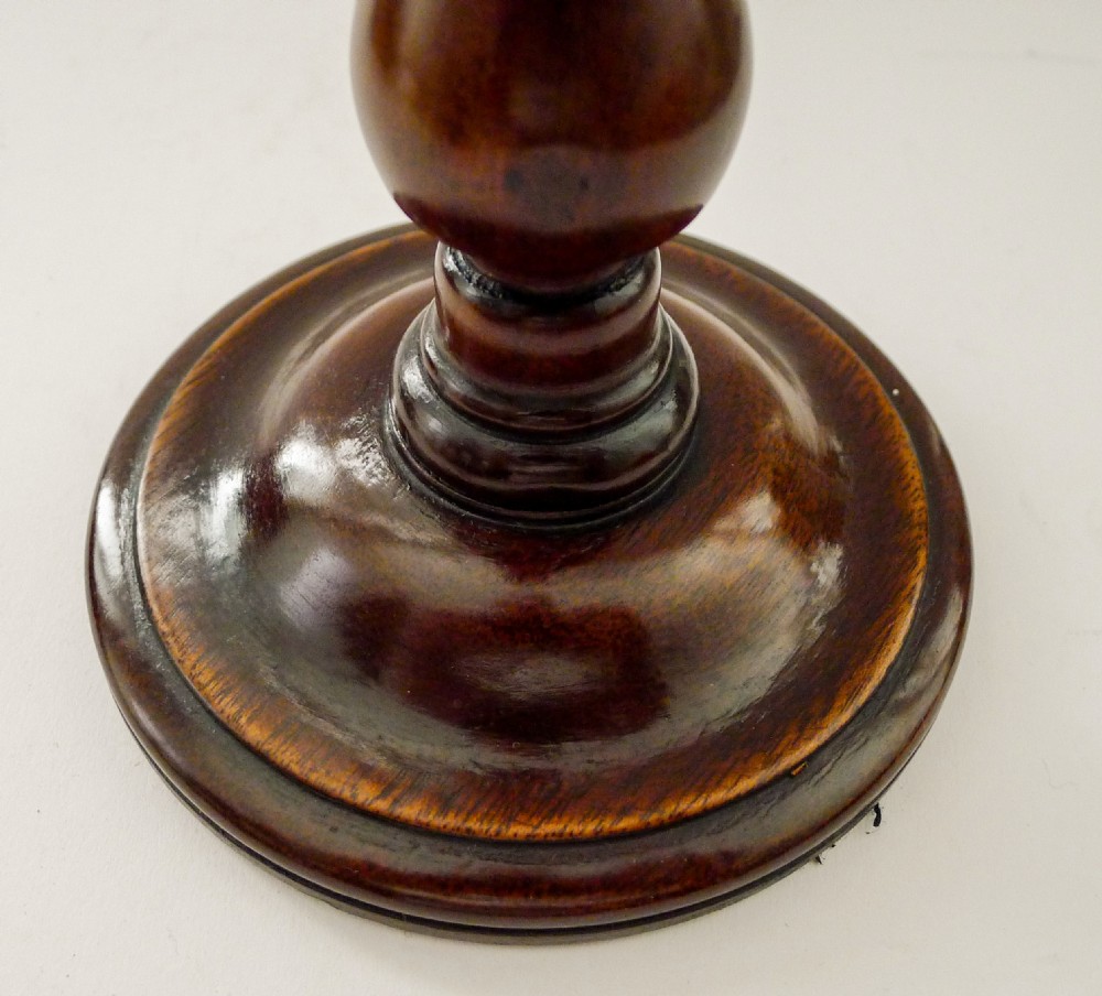 A pair of turned mahogany candlesticks with slender wooden shafts, circular bases, and polished brass sconces. View II