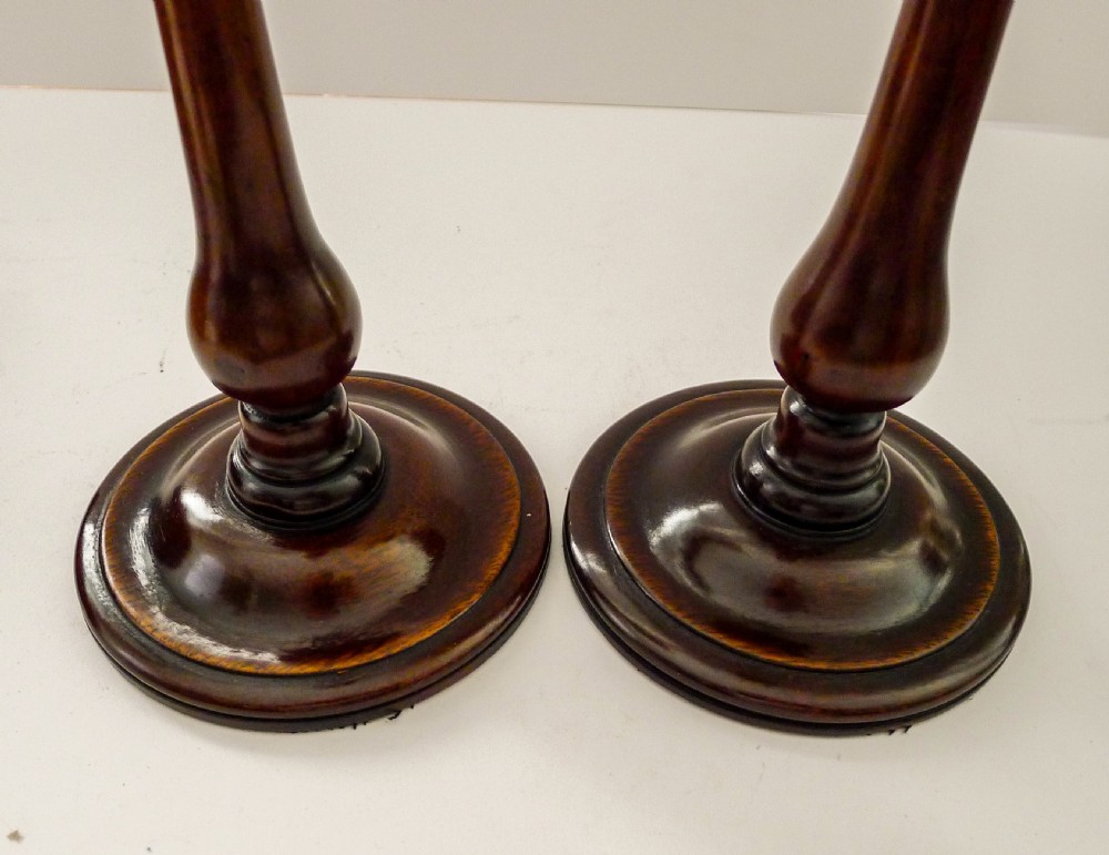 A pair of turned mahogany candlesticks with slender wooden shafts, circular bases, and polished brass sconces. View III