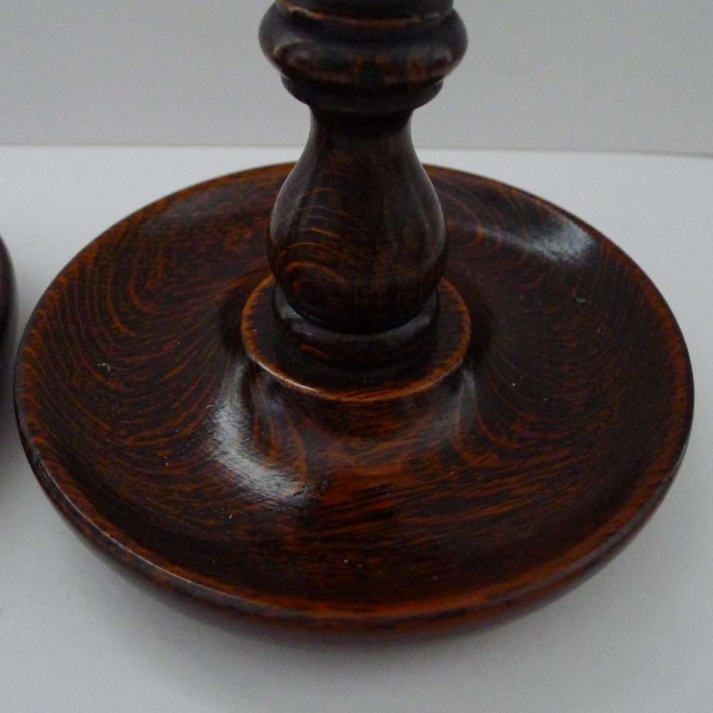 A pair of dark oak candlesticks featuring open barley twist stems and brass nozzles set on circular bases. View VI