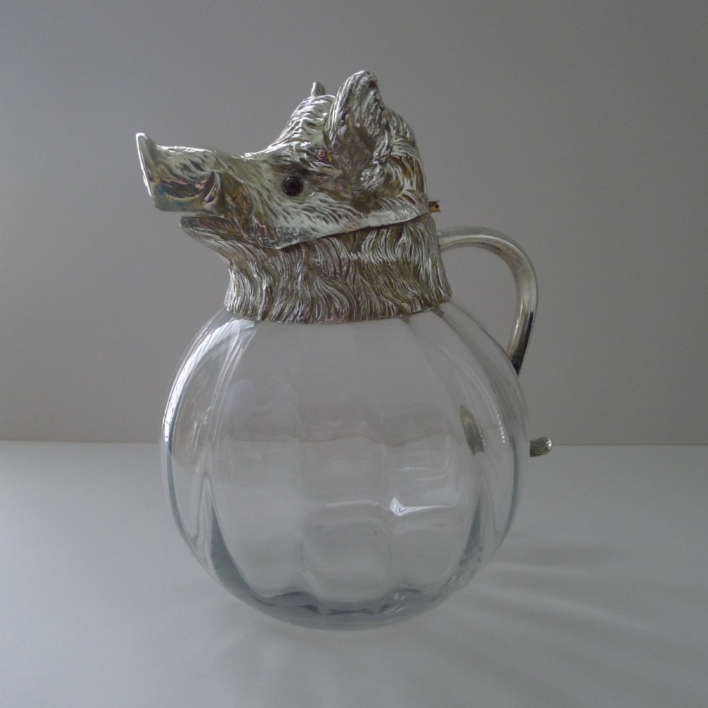 A spherical clear glass jug featuring a detailed cast silver-plated boar head spout and a curved silver handle. View II