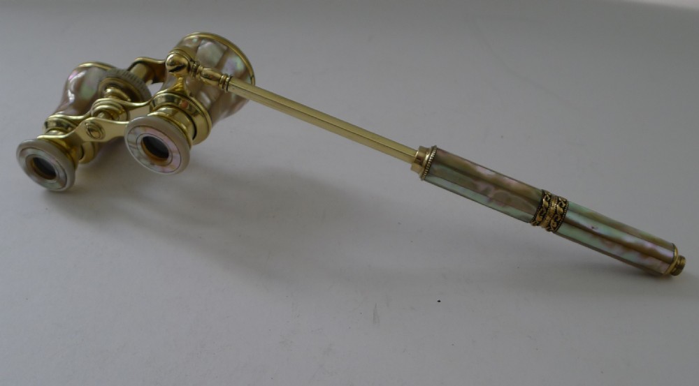 French brass opera glasses featuring mother-of-pearl shell cladding and an extendable side handle on a plain background. View II