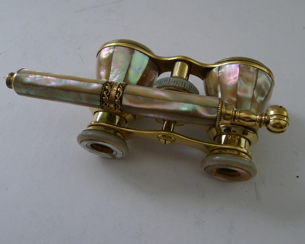 French brass opera glasses featuring mother-of-pearl shell cladding and an extendable side handle on a plain background. View VI