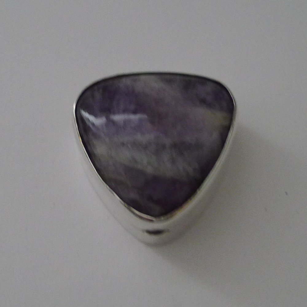 A triangular sterling silver pill box fitted with a smooth purple amethyst cabochon lid.