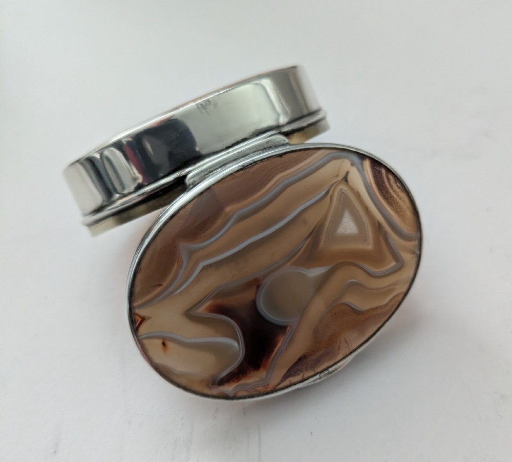 An oval Edwardian sterling silver box featuring polished natural agate stone panels on the hinged top and base. View II